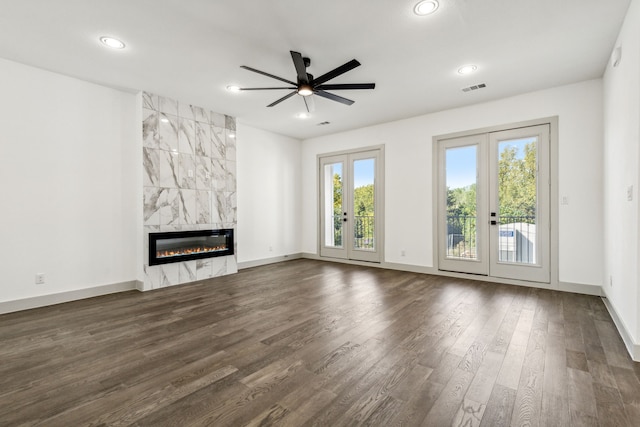 unfurnished living room with french doors, ceiling fan, a fireplace, and dark hardwood / wood-style floors