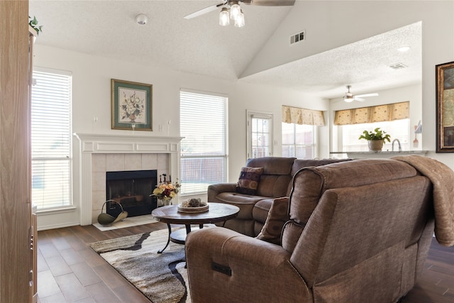 living room with ceiling fan, a healthy amount of sunlight, and a fireplace