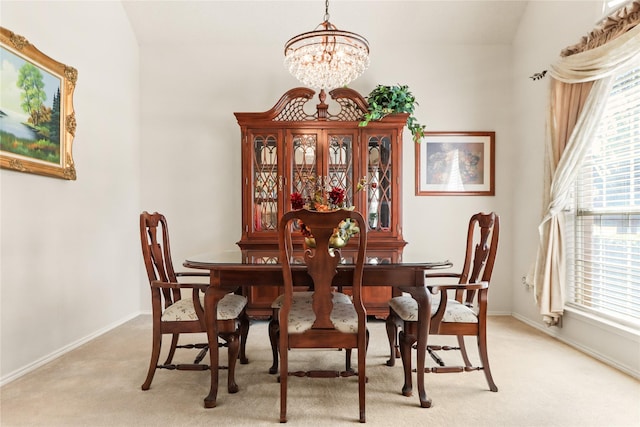 carpeted dining room with a chandelier and vaulted ceiling