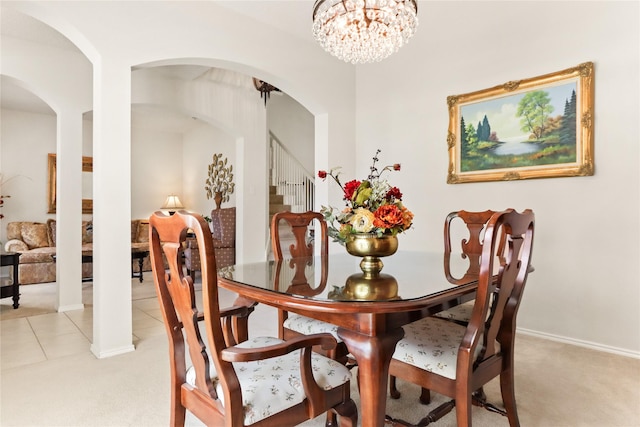 carpeted dining room featuring an inviting chandelier