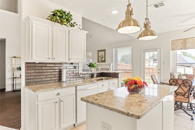 kitchen featuring white cabinets, a center island, sink, hanging light fixtures, and white dishwasher