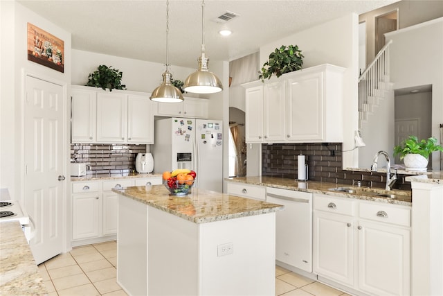 kitchen with white cabinets, sink, white appliances, and a center island