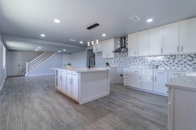 kitchen featuring white cabinetry, wall chimney exhaust hood, and light hardwood / wood-style floors