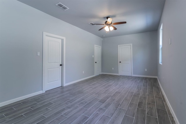 empty room with ceiling fan and dark wood-type flooring