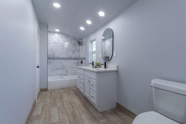 full bathroom with hardwood / wood-style flooring, tiled shower / bath combo, toilet, and vanity