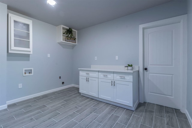 laundry area with electric dryer hookup, cabinets, light wood-type flooring, and hookup for a washing machine