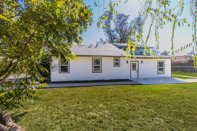 back of property with a lawn and a patio