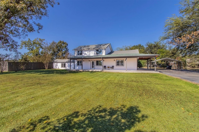 back of house with a carport, covered porch, and a yard