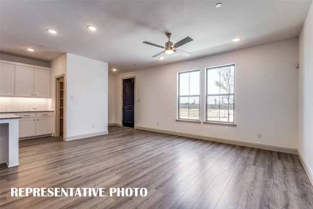 unfurnished living room with light hardwood / wood-style flooring and ceiling fan