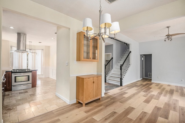 interior space featuring ceiling fan with notable chandelier, light hardwood / wood-style floors, and a textured ceiling