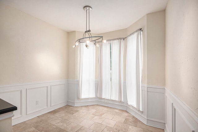 unfurnished dining area with an inviting chandelier