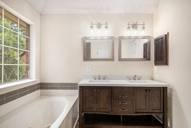 bathroom with vanity, plenty of natural light, and a textured ceiling