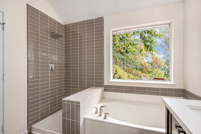 bathroom with a healthy amount of sunlight, independent shower and bath, and a textured ceiling