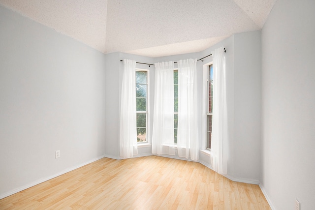 empty room with light hardwood / wood-style floors and a textured ceiling