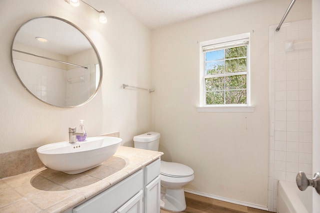 full bathroom featuring vanity, tiled shower / bath, hardwood / wood-style floors, and toilet