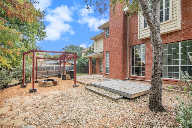 view of yard with a wooden deck, an outdoor fire pit, a pergola, and a patio area