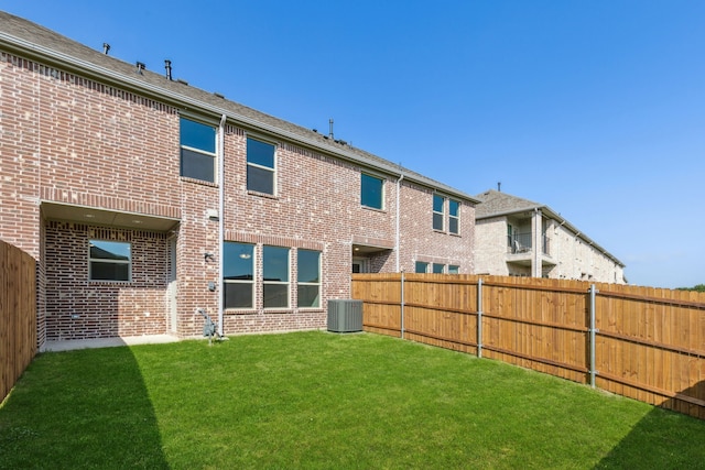 rear view of property with a yard and cooling unit