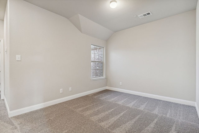 spare room featuring lofted ceiling and carpet