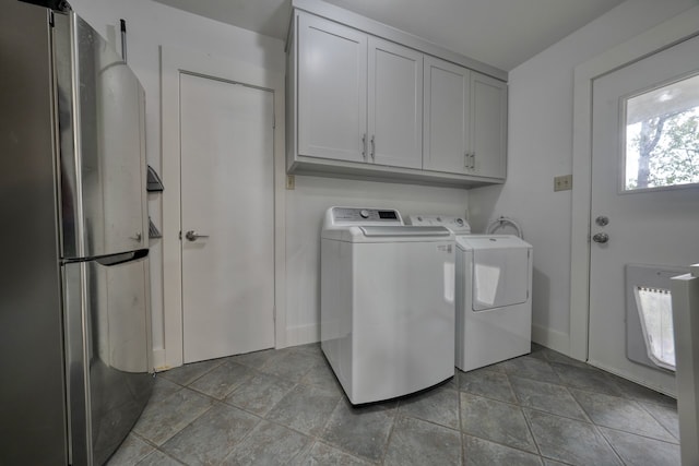 clothes washing area with cabinets and separate washer and dryer