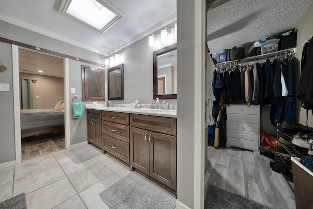 bathroom with vanity, crown molding, a textured ceiling, and tile patterned flooring