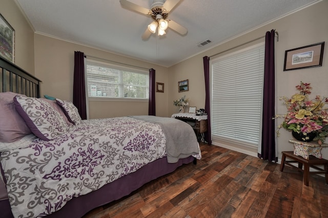 bedroom with ornamental molding, dark hardwood / wood-style floors, and ceiling fan