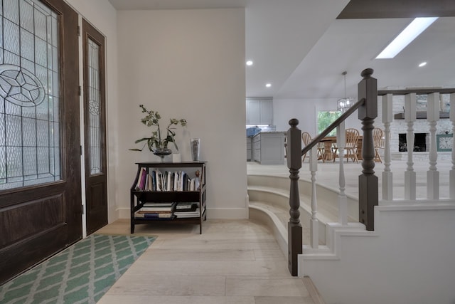 entrance foyer featuring light hardwood / wood-style flooring and a chandelier