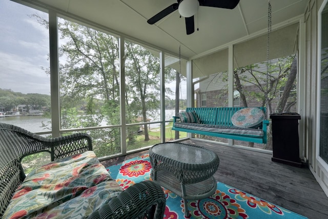 sunroom / solarium with a water view and ceiling fan