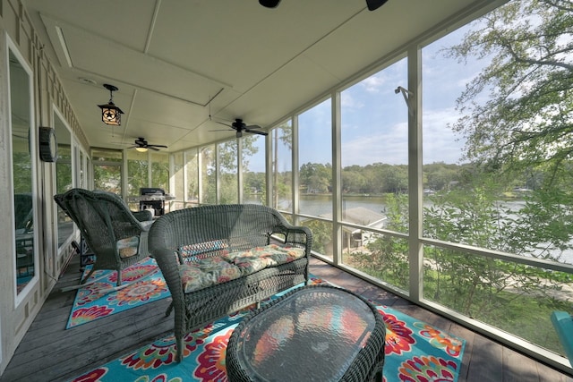 sunroom / solarium featuring a water view, ceiling fan, and a wealth of natural light