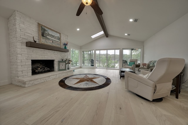 living room featuring a fireplace, light wood-type flooring, a healthy amount of sunlight, and ceiling fan