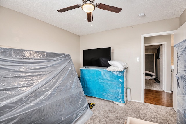 carpeted bedroom featuring a textured ceiling and ceiling fan