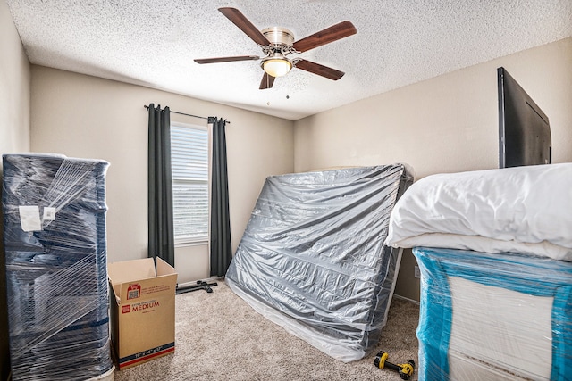 bedroom featuring ceiling fan, carpet flooring, and a textured ceiling