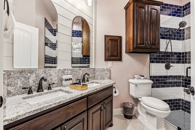 bathroom with a shower with door, backsplash, toilet, tile patterned floors, and vanity