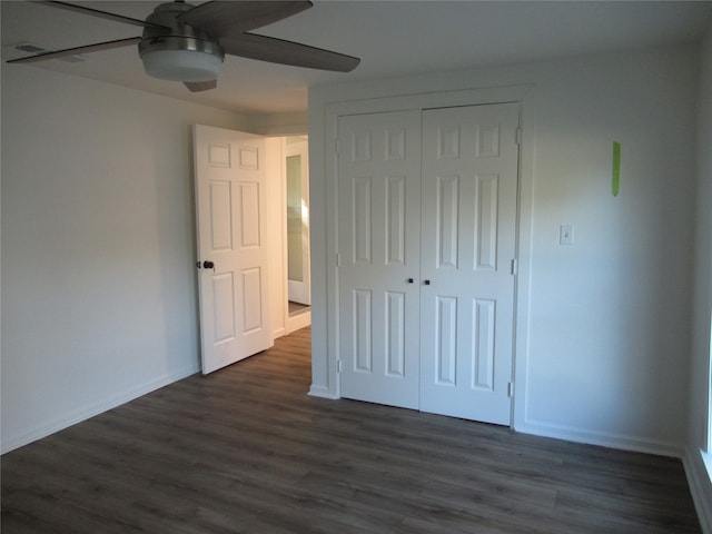 unfurnished bedroom with dark hardwood / wood-style floors, a closet, and ceiling fan