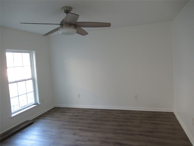 spare room with dark wood-type flooring and ceiling fan