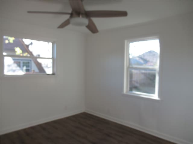 unfurnished room with dark wood-type flooring and ceiling fan