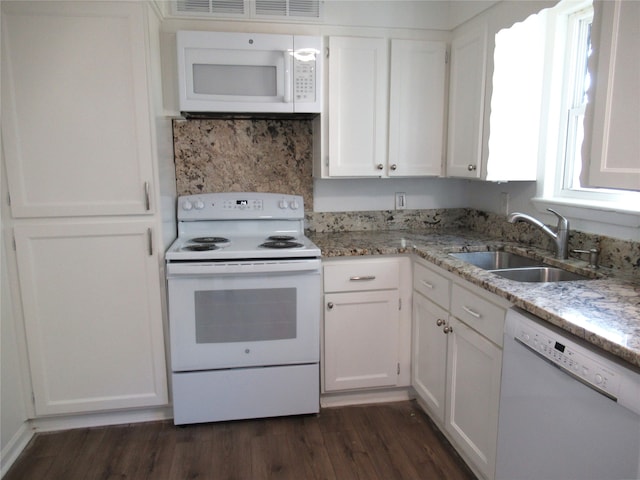 kitchen featuring white cabinetry, light stone countertops, dark wood-type flooring, sink, and white appliances