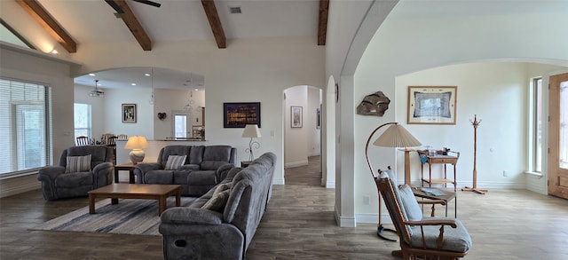 living area with arched walkways, beam ceiling, wood finished floors, and visible vents