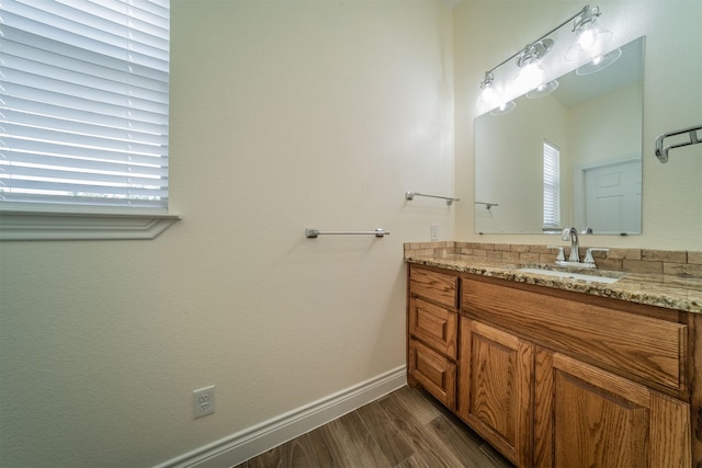 bathroom featuring baseboards, wood finished floors, and vanity