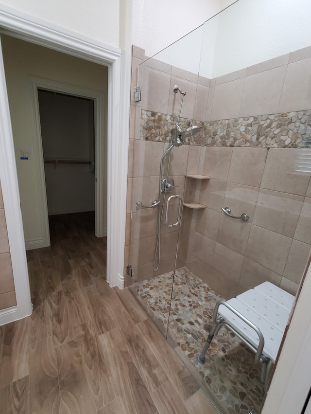 bathroom with a shower stall and wood finished floors