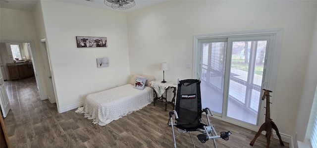 bedroom featuring access to exterior, dark wood finished floors, and baseboards