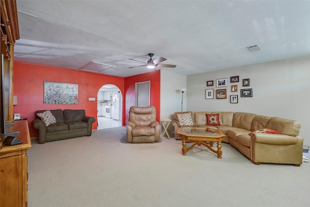 carpeted living room featuring ceiling fan and a textured ceiling