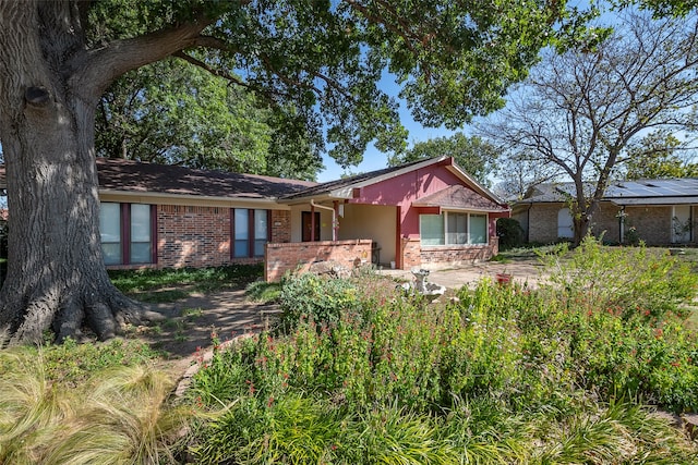 ranch-style house featuring brick siding