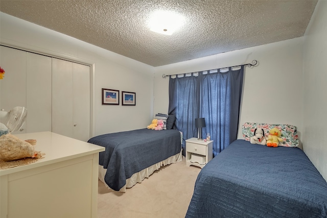 bedroom featuring light colored carpet, a closet, and a textured ceiling