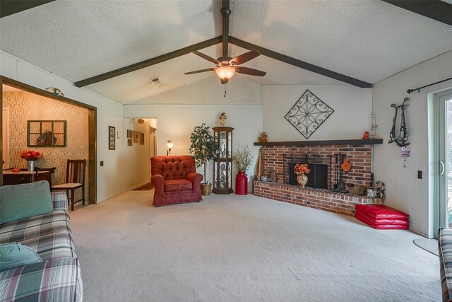 carpeted living room with ceiling fan, a fireplace, lofted ceiling with beams, and a textured ceiling