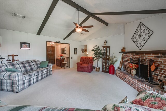 carpeted living room with ceiling fan, a textured ceiling, a brick fireplace, and vaulted ceiling with beams