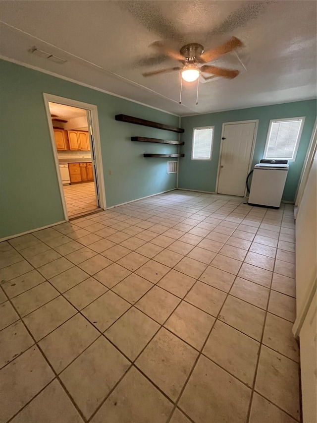 interior space with washer / dryer, ceiling fan, and a textured ceiling