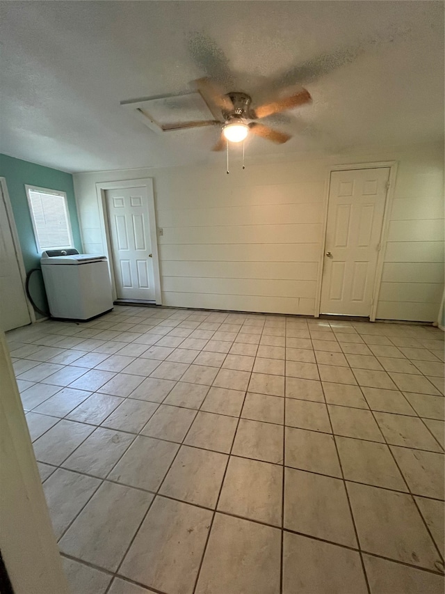 unfurnished room with washer / dryer, ceiling fan, a textured ceiling, and light tile patterned floors