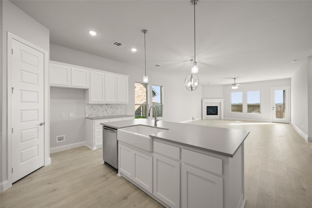 kitchen featuring white cabinetry, dishwasher, a healthy amount of sunlight, and sink