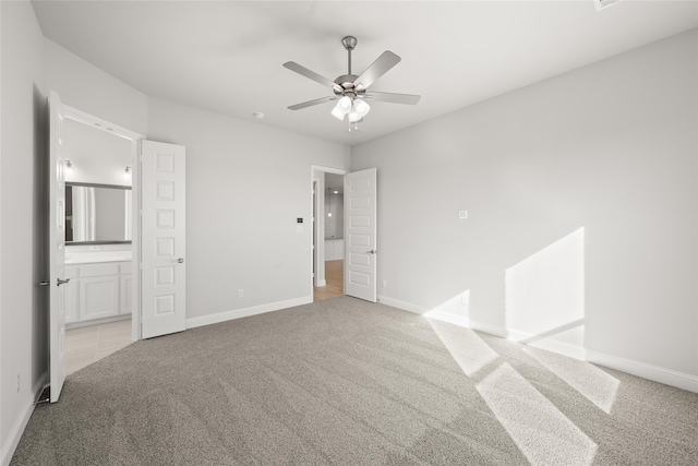 unfurnished bedroom featuring connected bathroom, light colored carpet, and ceiling fan