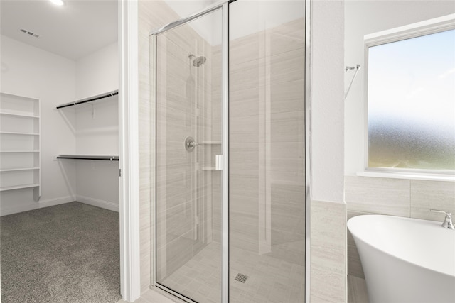 bathroom featuring separate shower and tub and tile walls